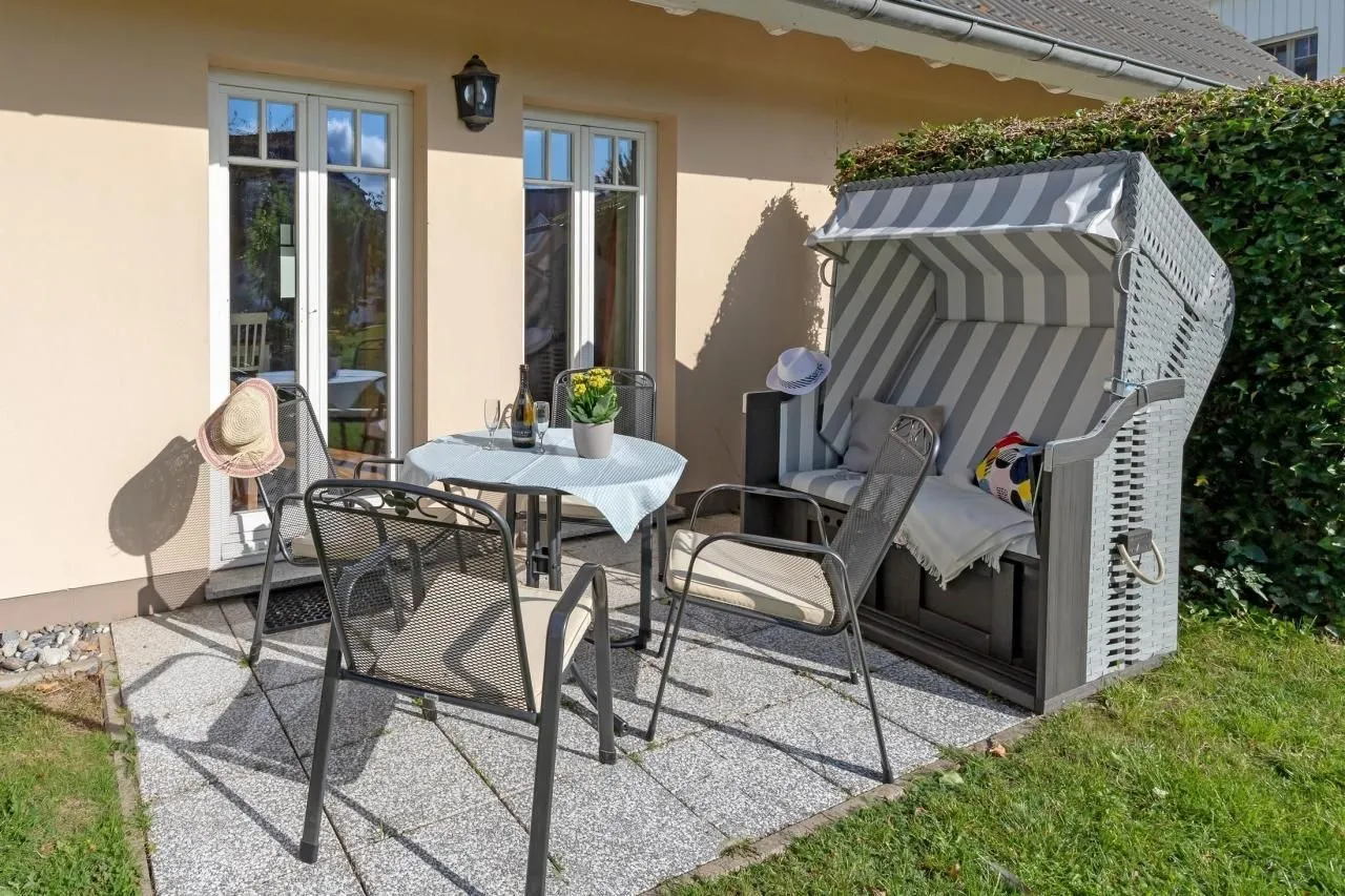 Sonnige Terrasse mit Sitzgruppe und Strandkorb